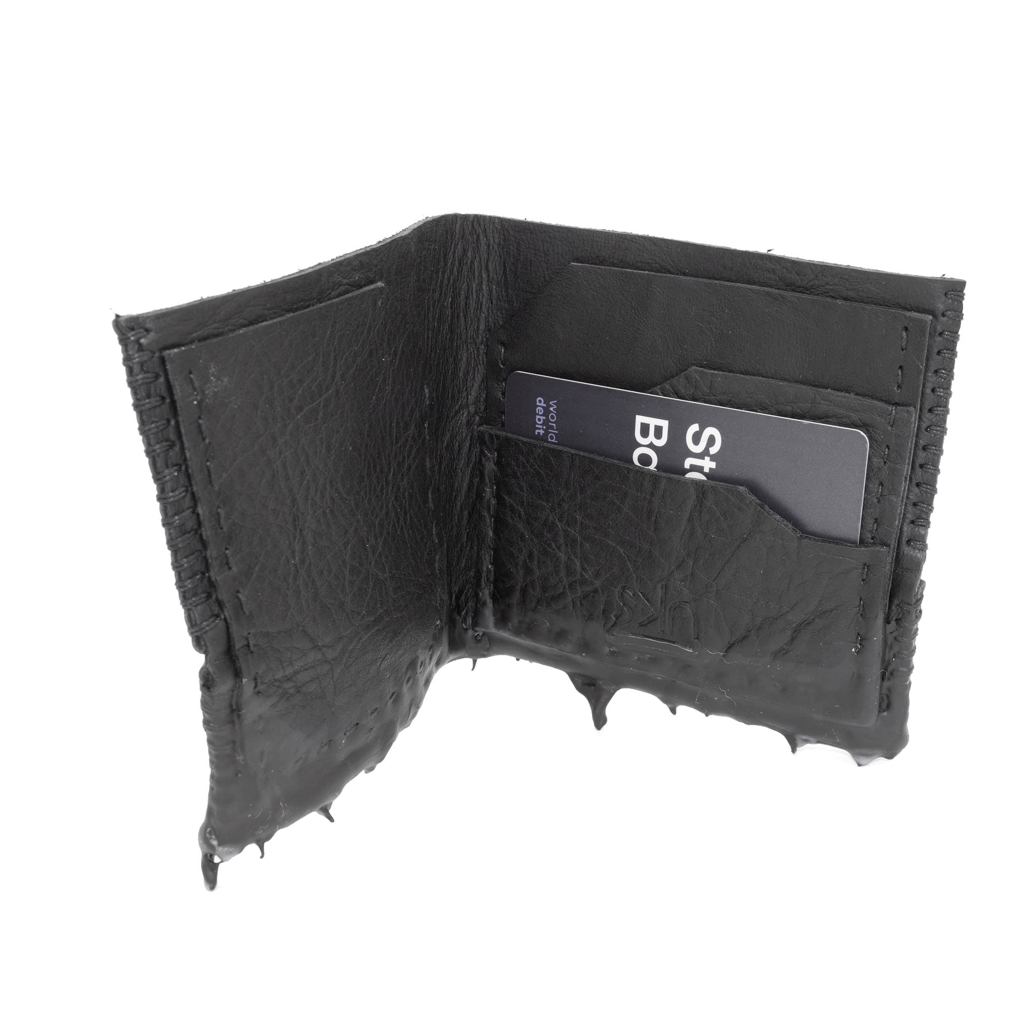 a closed seam 4 pocket bifold wallet crafted from a supple matte black washed horse leather with a closed seam construction. the wallet features a tonal rubber drip and is available to buy online from artisanal leather studio atelierskn.com