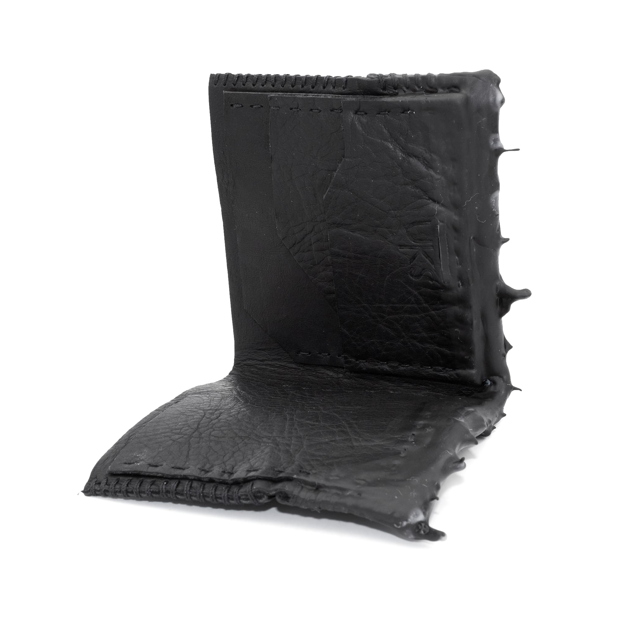 a closed seam 4 pocket bifold wallet crafted from a supple matte black washed horse leather with a closed seam construction. the wallet features a tonal rubber drip and is available to buy online from artisanal leather studio atelierskn.com