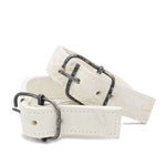 avant garde hand stitched horse culatta leather bicep belts, in a crushed bone finish. the arm cuffs feature a minimal silhouette with tonal japanese linen stitching and a hand forged .925 sterling silver buckle hardware. the arm belts are available to buy online from artisanal designer atelierskn.com 