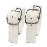 avant garde hand stitched horse culatta leather bicep belts, in a crushed bone finish. the arm cuffs feature a minimal silhouette with tonal japanese linen stitching and a hand forged .925 sterling silver buckle hardware. the arm belts are available to buy online from artisanal designer atelierskn.com 