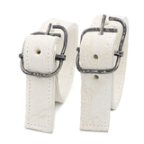 avant garde hand stitched horse culatta leather bicep belts, in a crushed bone finish. the arm cuffs feature a minimal silhouette with tonal japanese linen stitching and a hand forged .925 sterling silver buckle hardware. the arm belts are available to buy online from artisanal designer atelierskn.com 