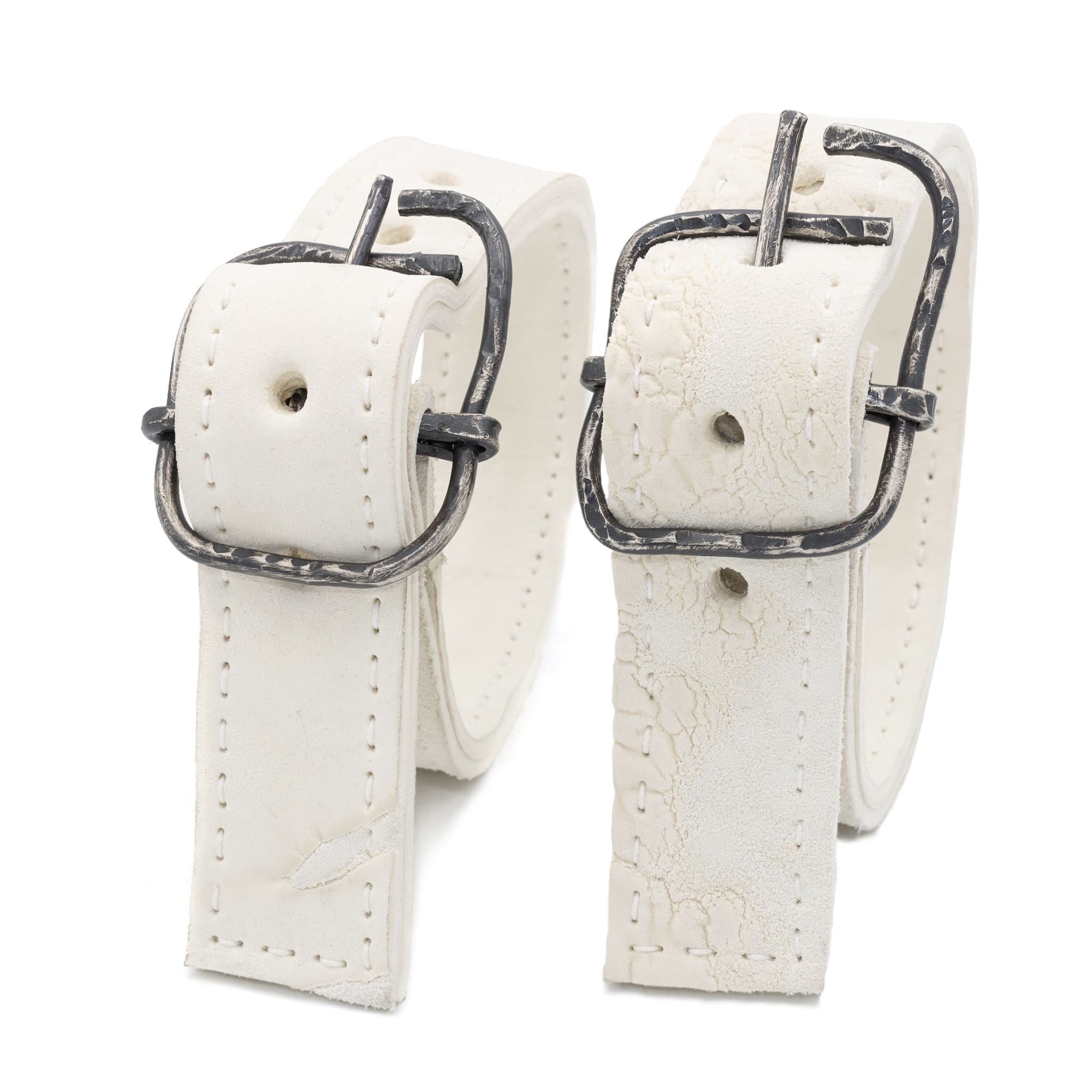 avant garde hand stitched horse culatta leather bicep belts, in a crushed bone finish. the arm cuffs feature a minimal silhouette with tonal japanese linen stitching and a hand forged .925 sterling silver buckle hardware. the arm belts are available to buy online from artisanal designer atelierskn.com 