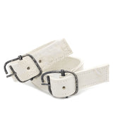 avant garde hand stitched horse culatta leather bicep belts, in a crushed bone finish. the arm cuffs feature a minimal silhouette with tonal japanese linen stitching and a hand forged .925 sterling silver buckle hardware. the arm belts are available to buy online from artisanal designer atelierskn.com 