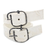avant garde hand stitched horse culatta leather bicep belts, in a crushed bone finish. the arm cuffs feature a minimal silhouette with tonal japanese linen stitching and a hand forged .925 sterling silver buckle hardware. the arm belts are available to buy online from artisanal designer atelierskn.com 