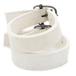 avant garde hand stitched horse culatta leather bicep belts, in a crushed bone finish. the arm cuffs feature a minimal silhouette with tonal japanese linen stitching and a hand forged .925 sterling silver buckle hardware. the arm belts are available to buy online from artisanal designer atelierskn.com 