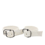 avant garde hand stitched horse culatta leather bicep belts, in a crushed bone finish. the arm cuffs feature a minimal silhouette with tonal japanese linen stitching and a hand forged .925 sterling silver buckle hardware. the arm belts are available to buy online from artisanal designer atelierskn.com 