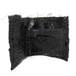 black crocodile leather wallet hand stitched over a 10 hour period. the genuine crocodile leather bifold wallet features multiple card slots, and a japanese ramie lining. an open seam construction and overlocked sides are hand stitched in a japanese linen thread. the wallet is available to buy online from avant garde leather studio atelierskn.com