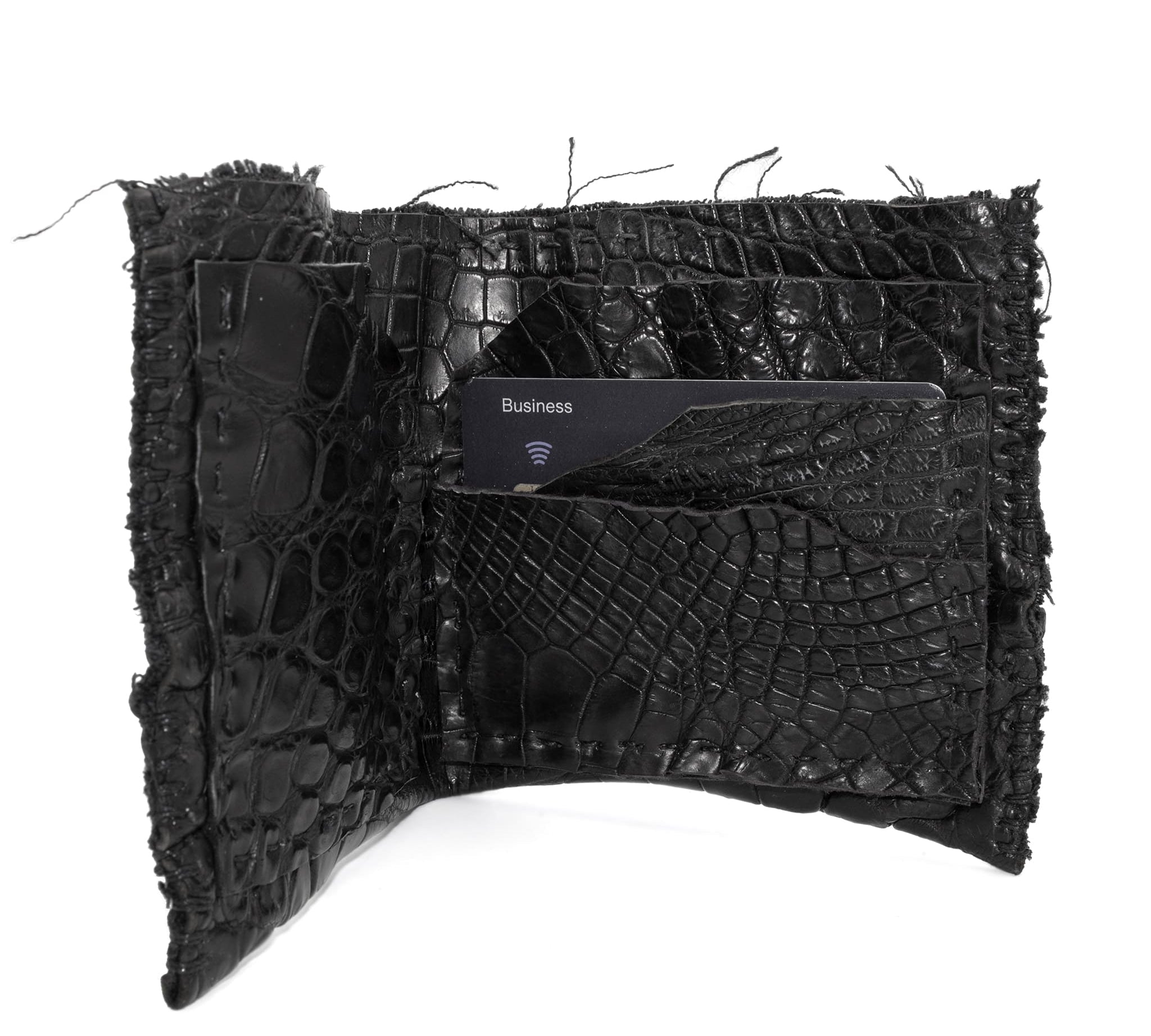 black crocodile leather wallet hand stitched over a 10 hour period. the genuine crocodile leather bifold wallet features multiple card slots, and a japanese ramie lining. an open seam construction and overlocked sides are hand stitched in a japanese linen thread. the wallet is available to buy online from avant garde leather studio atelierskn.com