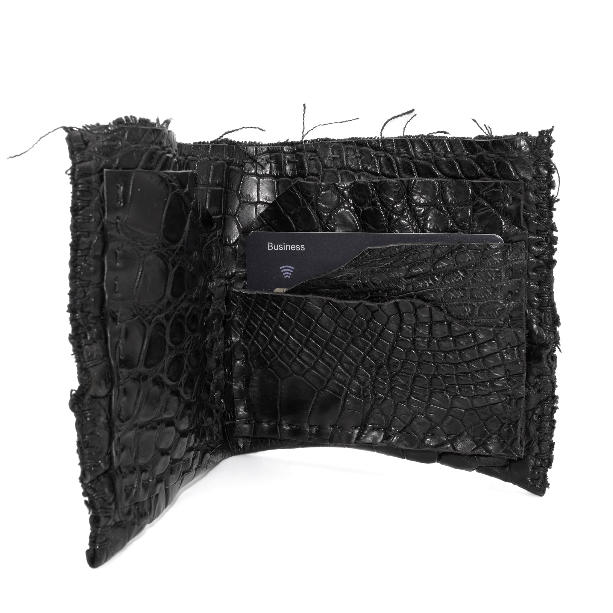 black crocodile leather wallet hand stitched over a 10 hour period. the genuine crocodile leather bifold wallet features multiple card slots, and a japanese ramie lining. an open seam construction and overlocked sides are hand stitched in a japanese linen thread. the wallet is available to buy online from avant garde leather studio atelierskn.com