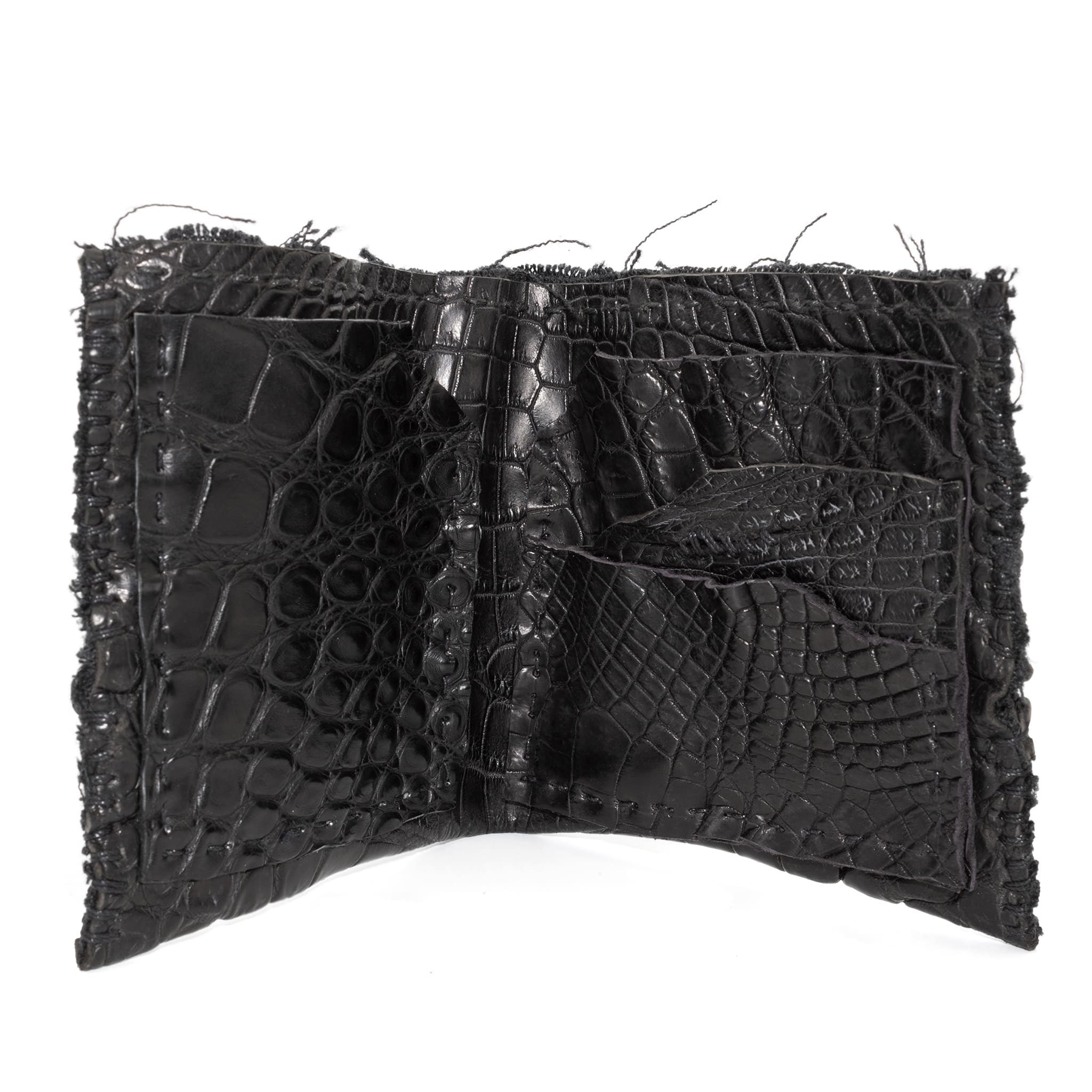 black crocodile leather wallet hand stitched over a 10 hour period. the genuine crocodile leather bifold wallet features multiple card slots, and a japanese ramie lining. an open seam construction and overlocked sides are hand stitched in a japanese linen thread. the wallet is available to buy online from avant garde leather studio atelierskn.com