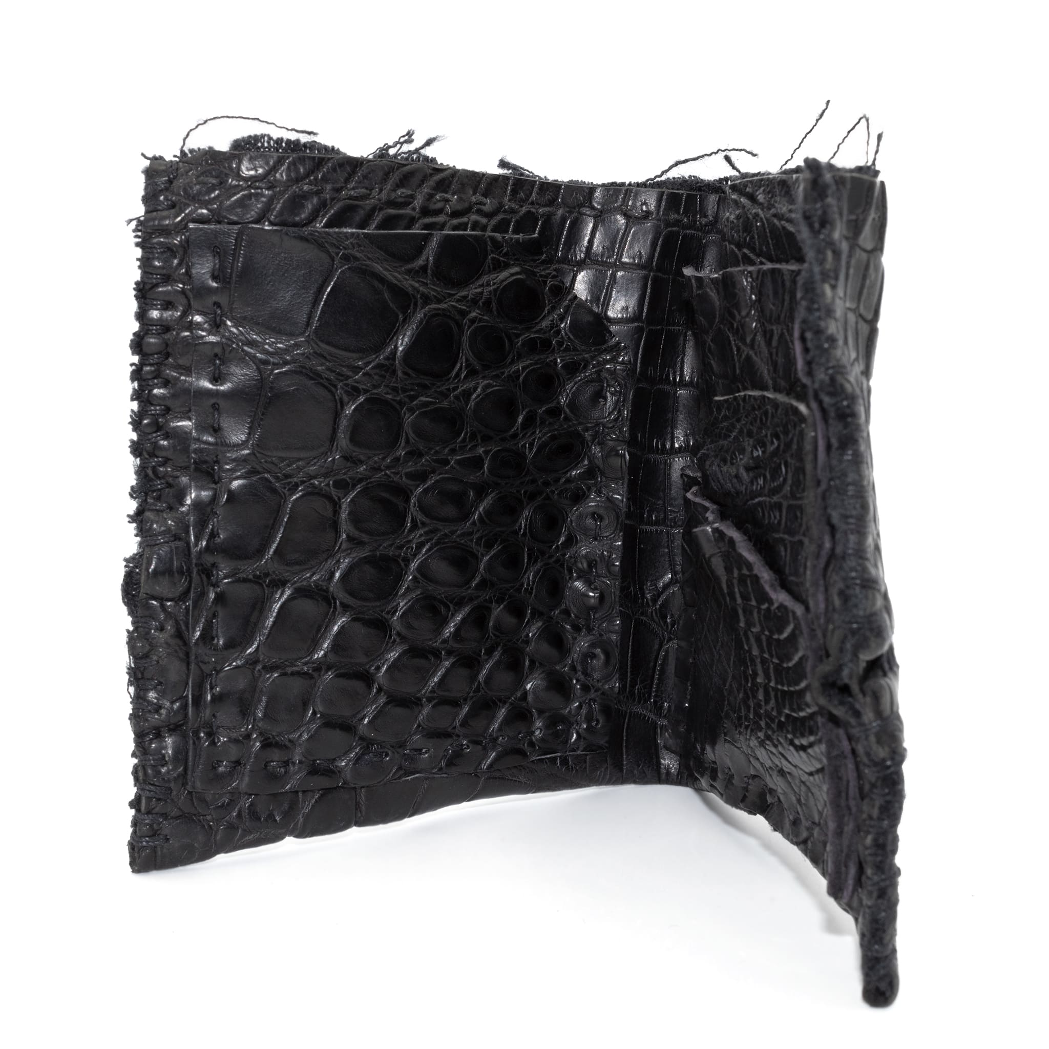 black crocodile leather wallet hand stitched over a 10 hour period. the genuine crocodile leather bifold wallet features multiple card slots, and a japanese ramie lining. an open seam construction and overlocked sides are hand stitched in a japanese linen thread. the wallet is available to buy online from avant garde leather studio atelierskn.com