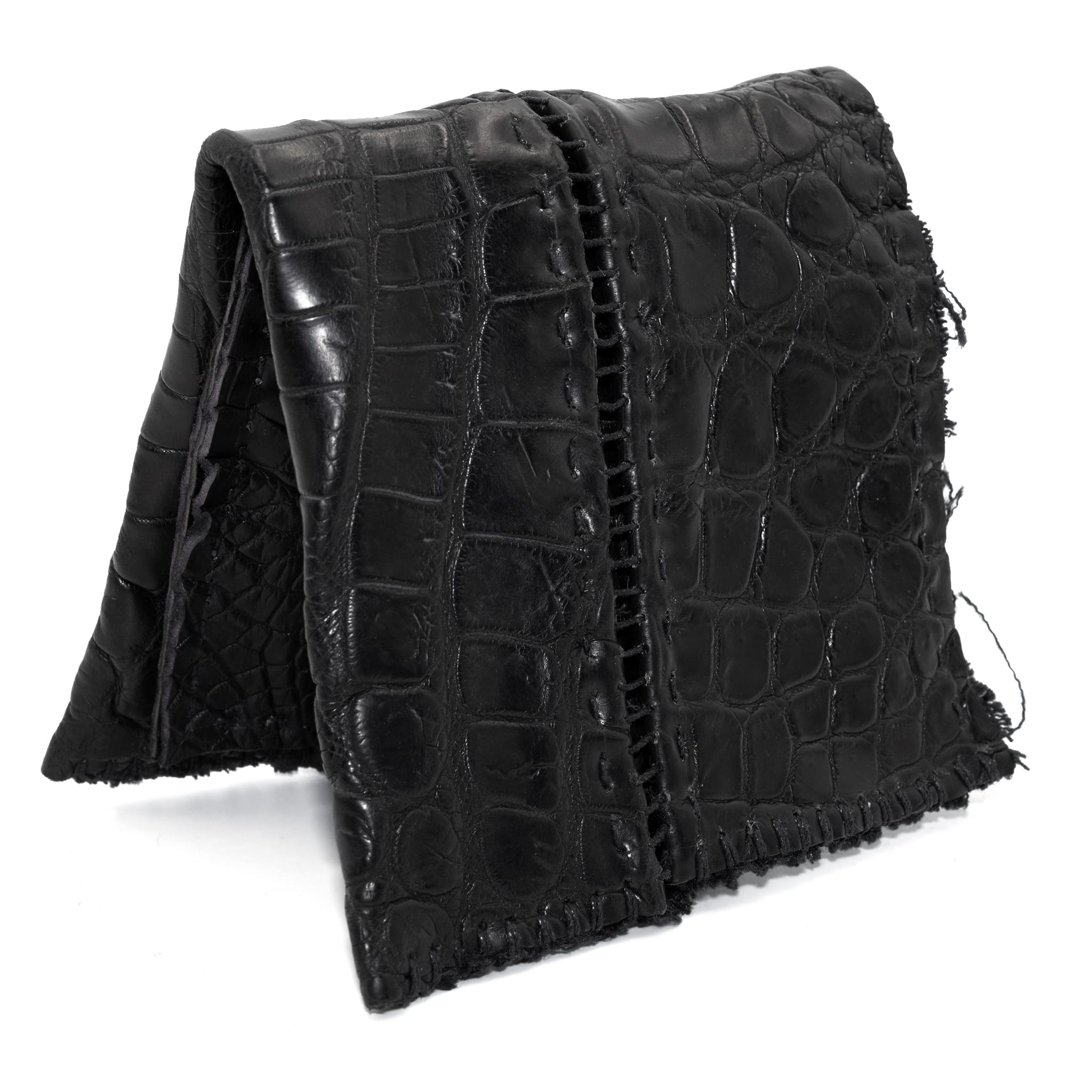 black crocodile leather wallet hand stitched over a 10 hour period. the genuine crocodile leather bifold wallet features multiple card slots, and a japanese ramie lining. an open seam construction and overlocked sides are hand stitched in a japanese linen thread. the wallet is available to buy online from avant garde leather studio atelierskn.com