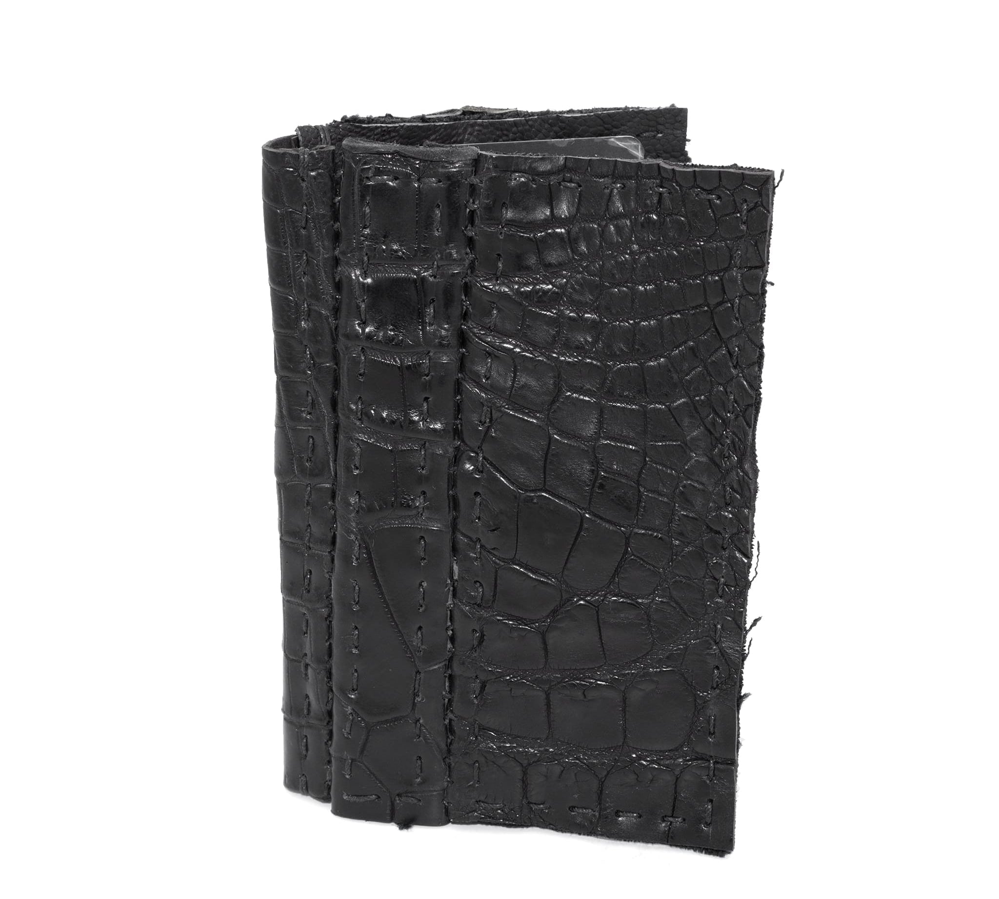 black crocodile leather cardholder, hand stitched over an 18 hour period without the use of machines. the genuine crocodile leather bifold card case features multiple card slots, and a japanese ramie lining. an open seam construction is hand stitched in a japanese linen thread. the wallet is available to buy online from avant garde leather studio atelierskn.com