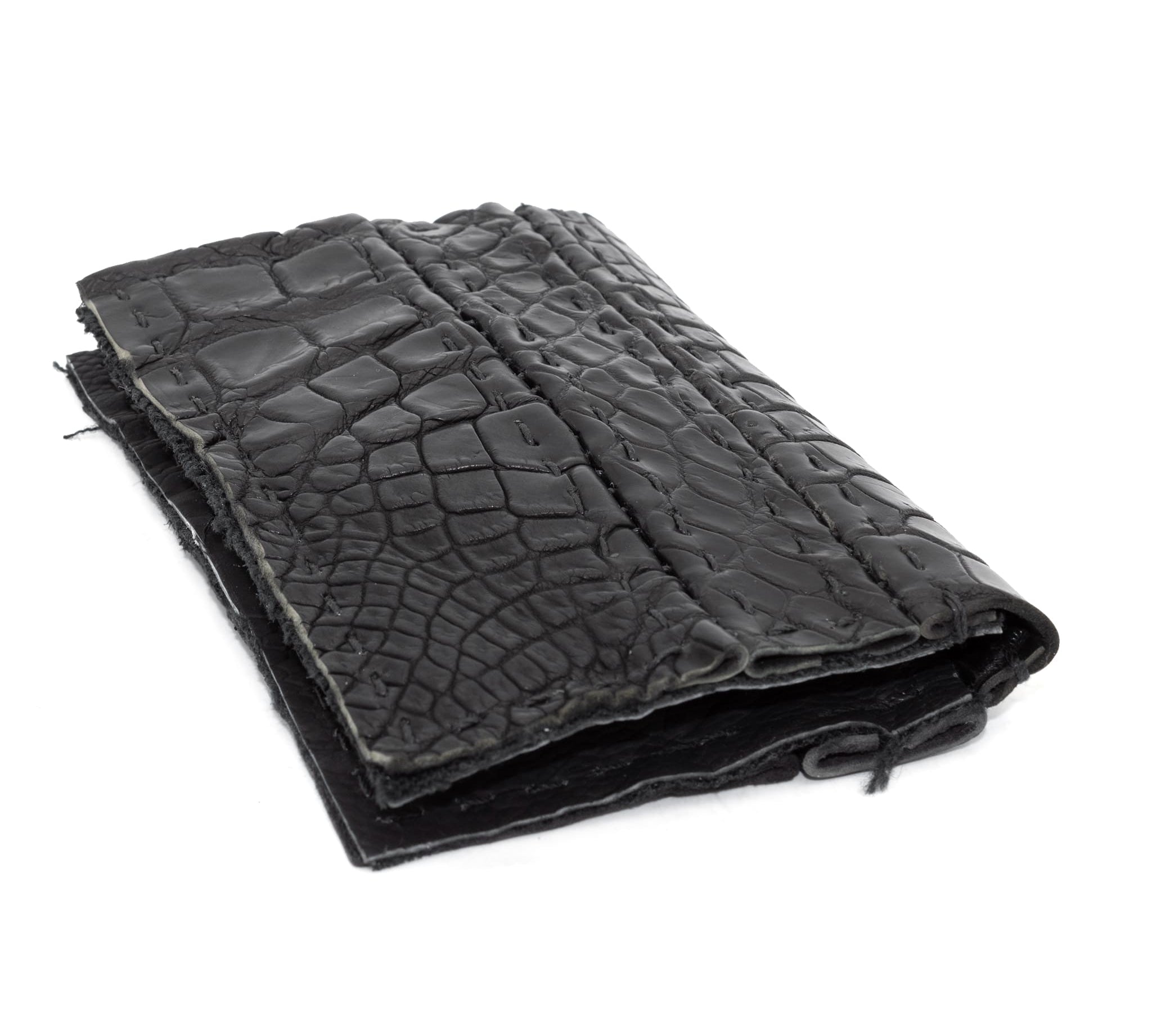 black crocodile leather cardholder, hand stitched over an 18 hour period without the use of machines. the genuine crocodile leather bifold card case features multiple card slots, and a japanese ramie lining. an open seam construction is hand stitched in a japanese linen thread. the wallet is available to buy online from avant garde leather studio atelierskn.com
