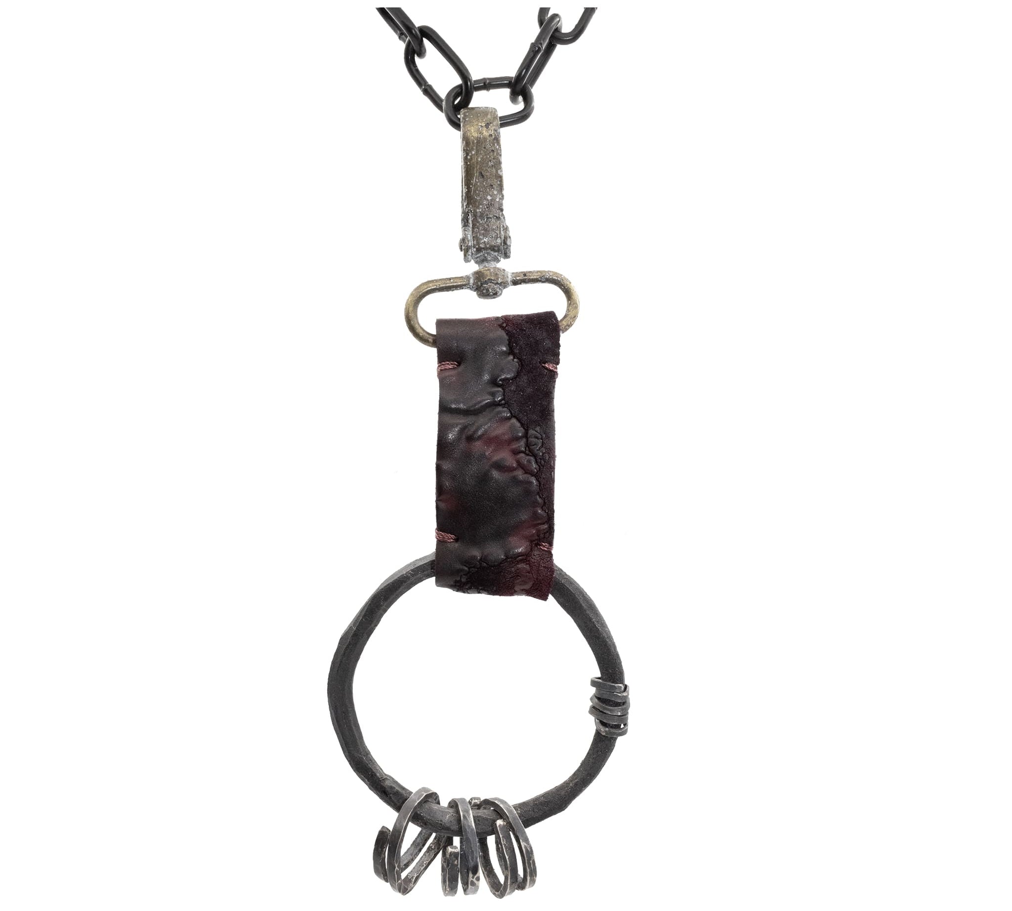 the hand sewn reverse culatta leather prison keys feature a blood red dye treatment and a distressed and corroded swivel clip. a large hand forged black iron ring holds the triple oxidised .925 silver key rings.