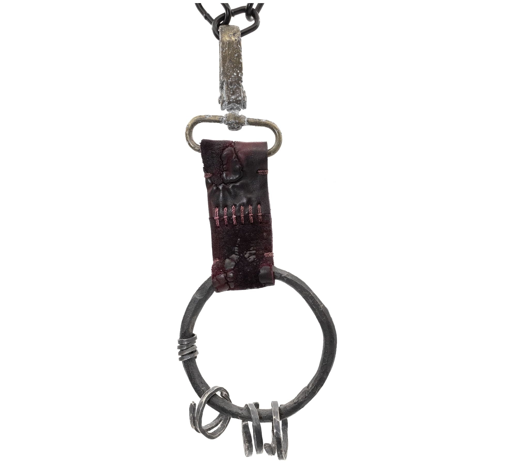 the hand sewn reverse culatta leather prison keys feature a blood red dye treatment and a distressed and corroded swivel clip. a large hand forged black iron ring holds the triple oxidised .925 silver key rings.