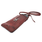 avant garde hand stitched culatta horse leather phone case, with a blood red dye finish. the phone case features a minimal silhouette with tonal japanese linen stitching and hand forged .925 sterling silver hardware. the phone holder is available to buy online from artisanal designer atelierskn.com 