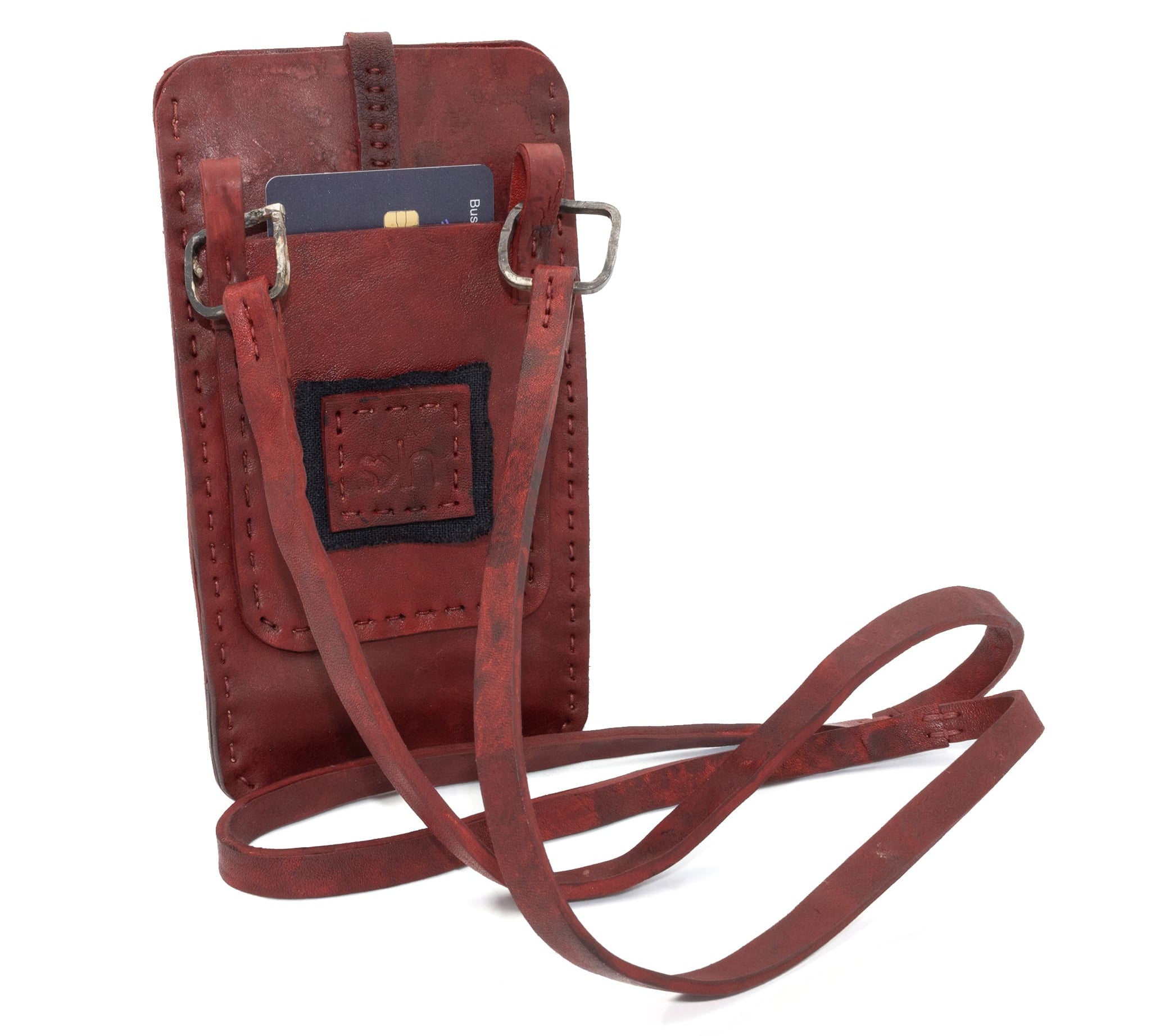 avant garde hand stitched culatta horse leather phone case, with a blood red dye finish. the phone case features a minimal silhouette with tonal japanese linen stitching and hand forged .925 sterling silver hardware. the phone holder is available to buy online from artisanal designer atelierskn.com 