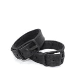 avant garde hand stitched horse culatta leather bicep belts, with an iron dye finish. the arm cuffs feature a minimal silhouette with tonal japanese linen stitching and hand forged iron buckle hardware. the arm belts are available to buy online from artisanal designer atelierskn.com 