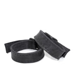 avant garde hand stitched horse culatta leather bicep belts, with an iron dye finish. the arm cuffs feature a minimal silhouette with tonal japanese linen stitching and hand forged iron buckle hardware. the arm belts are available to buy online from artisanal designer atelierskn.com 