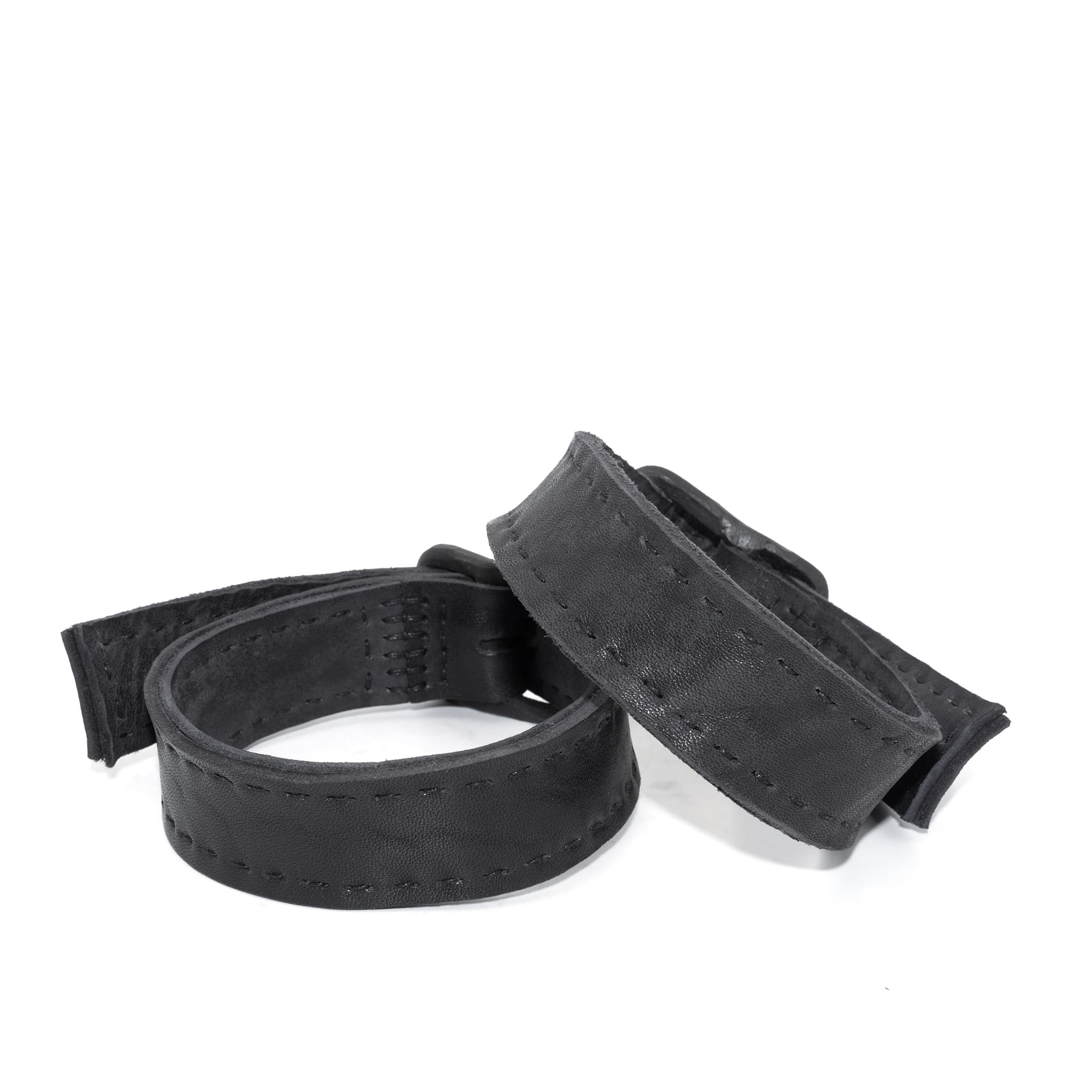 avant garde hand stitched horse culatta leather bicep belts, with an iron dye finish. the arm cuffs feature a minimal silhouette with tonal japanese linen stitching and hand forged iron buckle hardware. the arm belts are available to buy online from artisanal designer atelierskn.com 