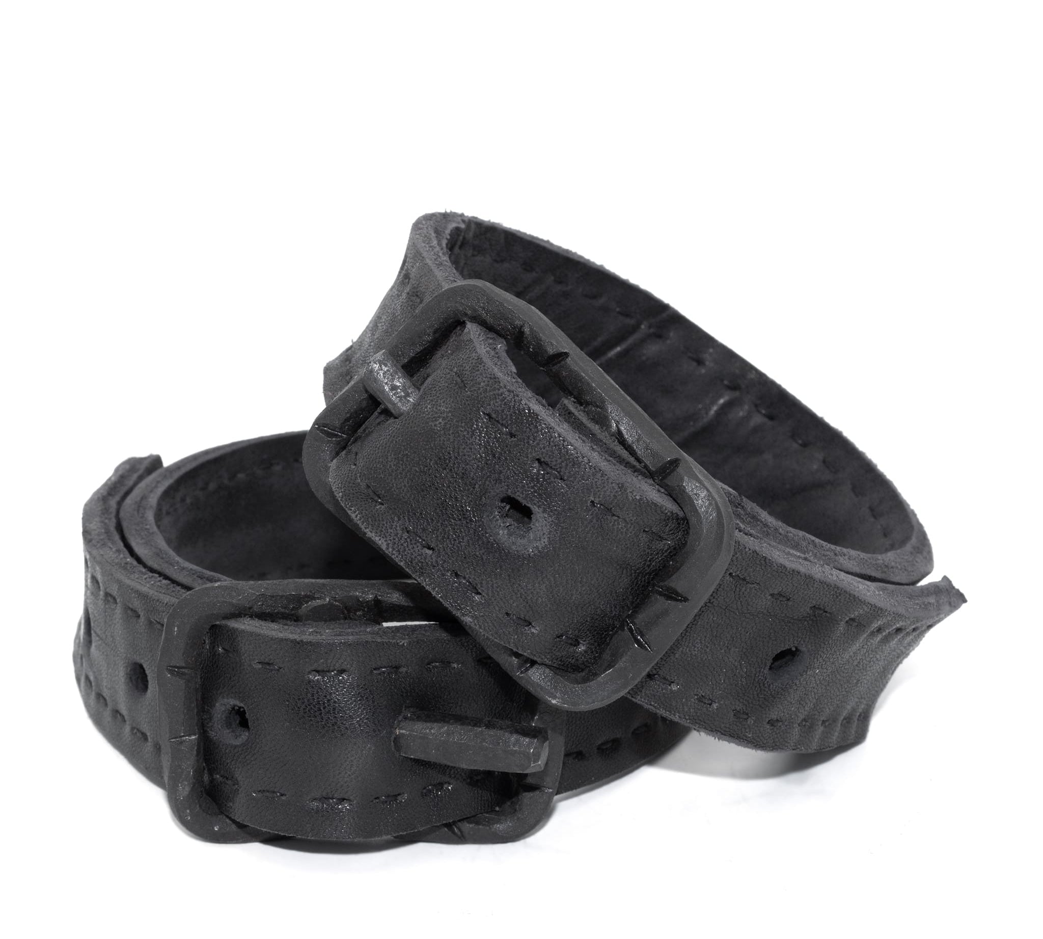 avant garde hand stitched horse culatta leather bicep belts, with an iron dye finish. the arm cuffs feature a minimal silhouette with tonal japanese linen stitching and hand forged iron buckle hardware. the arm belts are available to buy online from artisanal designer atelierskn.com 