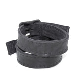 avant garde hand stitched horse culatta leather bicep belts, with an iron dye finish. the arm cuffs feature a minimal silhouette with tonal japanese linen stitching and hand forged iron buckle hardware. the arm belts are available to buy online from artisanal designer atelierskn.com 