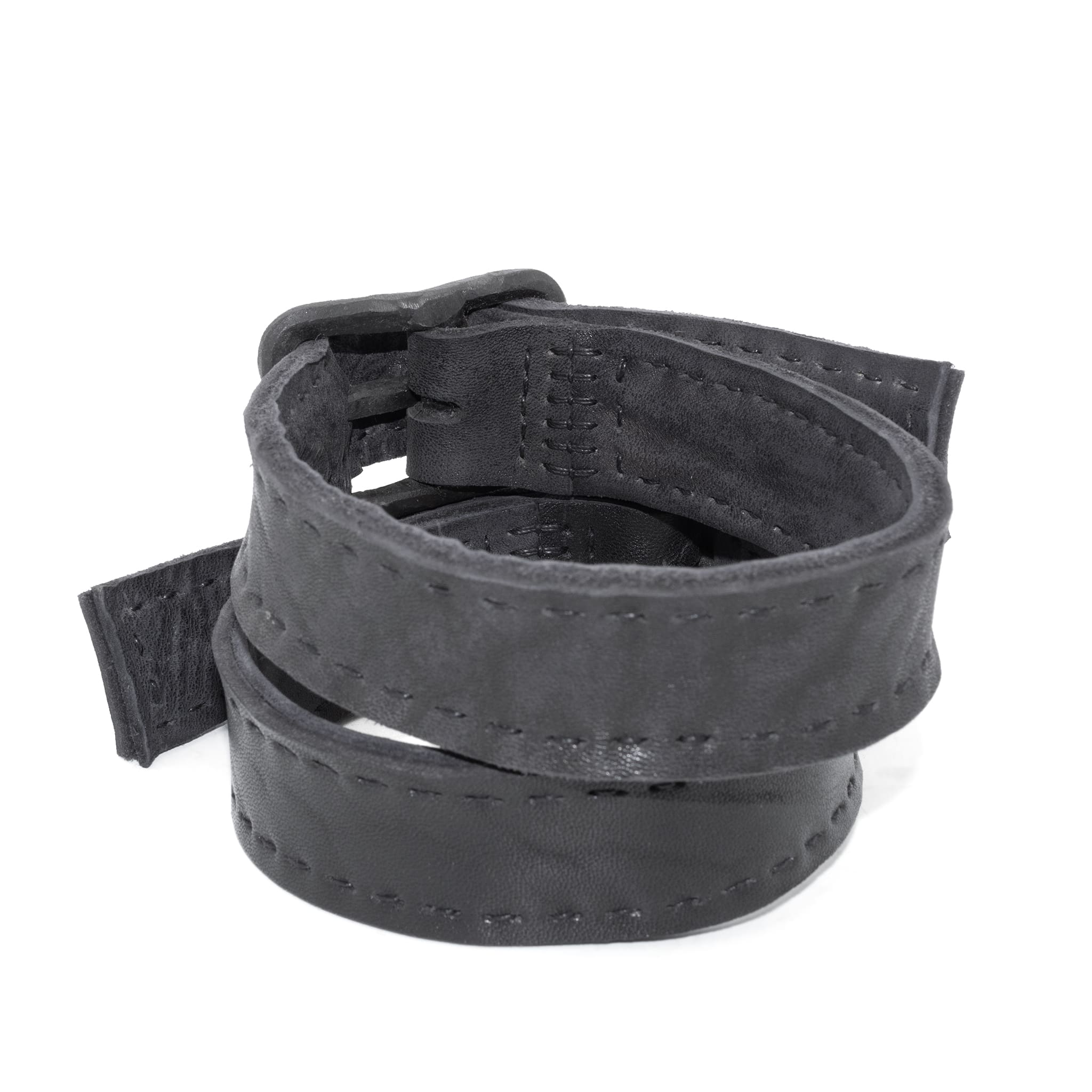 avant garde hand stitched horse culatta leather bicep belts, with an iron dye finish. the arm cuffs feature a minimal silhouette with tonal japanese linen stitching and hand forged iron buckle hardware. the arm belts are available to buy online from artisanal designer atelierskn.com 