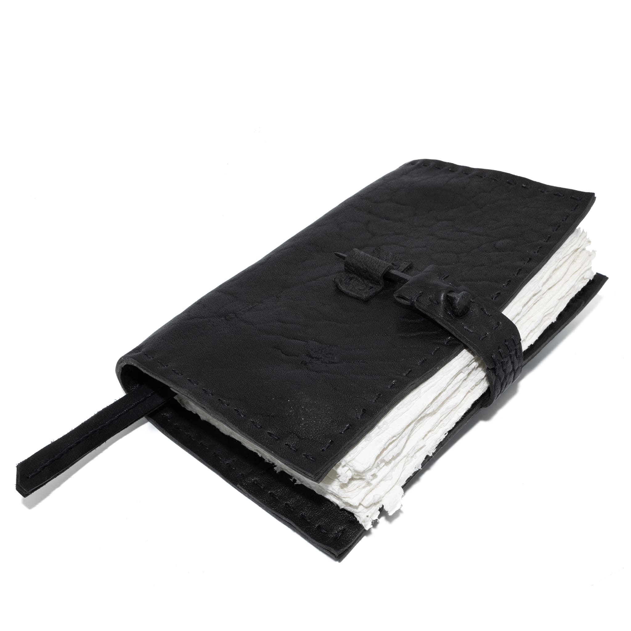 Hand stitched matte black horse culatta leather journal with a hand forged coffin nail closure and 80 pages of 150gsm handmade cotton rag paper available to buy online from artisanal uk based leather studio atelier skn.