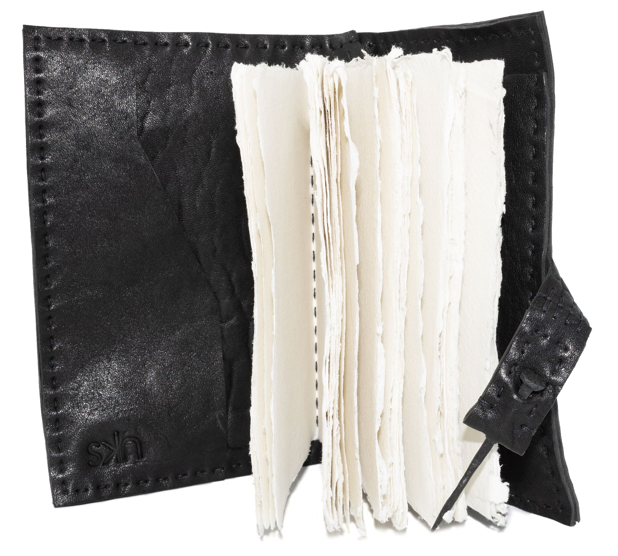 Hand stitched matte black horse culatta leather journal with a hand forged coffin nail closure and 80 pages of 150gsm handmade cotton rag paper available to buy online from artisanal uk based leather studio atelier skn.