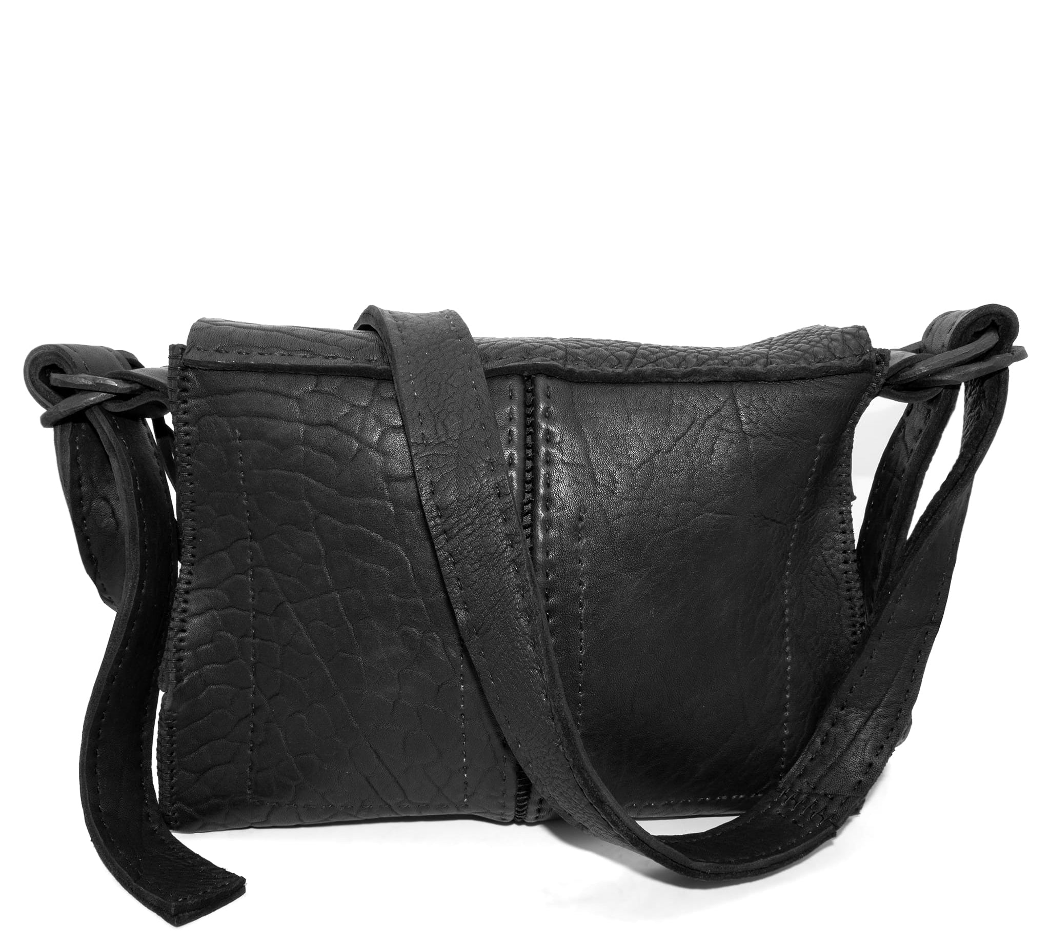 medium sized hand stitched washed horse culatta leather shoulder bag with an object dyed matte black finish. the bag features an open seam construction with a flap closure, riri zipper fastening and hand forged iron and silver hardware. the black leather bag is finished with an adjustable leather strap and is available to buy online from avant garde leather studio atelierskn.com.