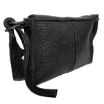 medium sized hand stitched washed horse culatta leather shoulder bag with an object dyed matte black finish. the bag features an open seam construction with a flap closure, riri zipper fastening and hand forged iron and silver hardware. the black leather bag is finished with an adjustable leather strap and is available to buy online from avant garde leather studio atelierskn.com.