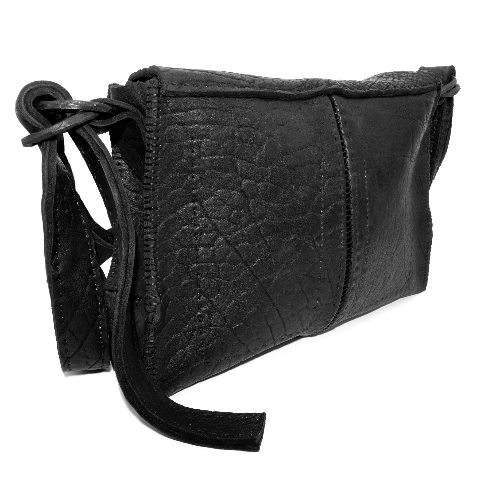 medium sized hand stitched washed horse culatta leather shoulder bag with an object dyed matte black finish. the bag features an open seam construction with a flap closure, riri zipper fastening and hand forged iron and silver hardware. the black leather bag is finished with an adjustable leather strap and is available to buy online from avant garde leather studio atelierskn.com.