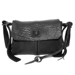 medium sized hand stitched washed horse culatta leather shoulder bag with an object dyed matte black finish. the bag features an open seam construction with a flap closure, riri zipper fastening and hand forged iron and silver hardware. the black leather bag is finished with an adjustable leather strap and is available to buy online from avant garde leather studio atelierskn.com.