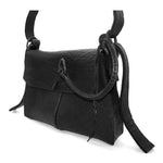 medium sized hand stitched washed horse culatta leather shoulder bag with an object dyed matte black finish. the bag features an open seam construction with a flap closure, riri zipper fastening and hand forged iron and silver hardware. the black leather bag is finished with an adjustable leather strap and is available to buy online from avant garde leather studio atelierskn.com.