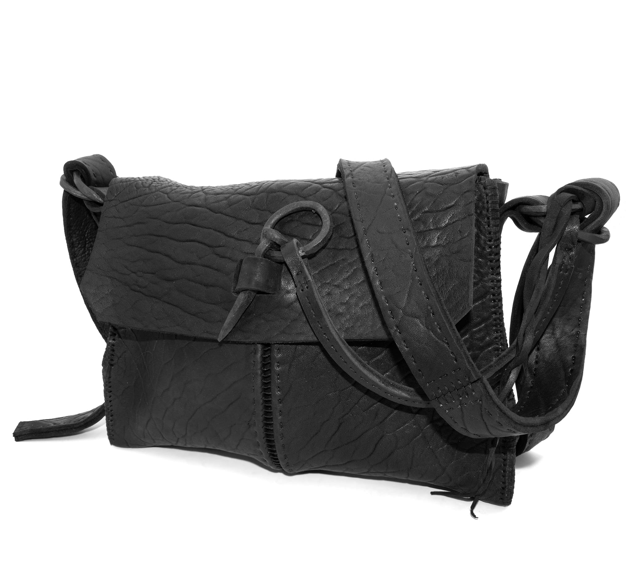 medium sized hand stitched washed horse culatta leather shoulder bag with an object dyed matte black finish. the bag features an open seam construction with a flap closure, riri zipper fastening and hand forged iron and silver hardware. the black leather bag is finished with an adjustable leather strap and is available to buy online from avant garde leather studio atelierskn.com.