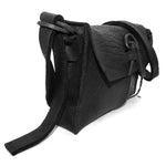 medium sized hand stitched washed horse culatta leather shoulder bag with an object dyed matte black finish. the bag features an open seam construction with a flap closure, riri zipper fastening and hand forged iron and silver hardware. the black leather bag is finished with an adjustable leather strap and is available to buy online from avant garde leather studio atelierskn.com.