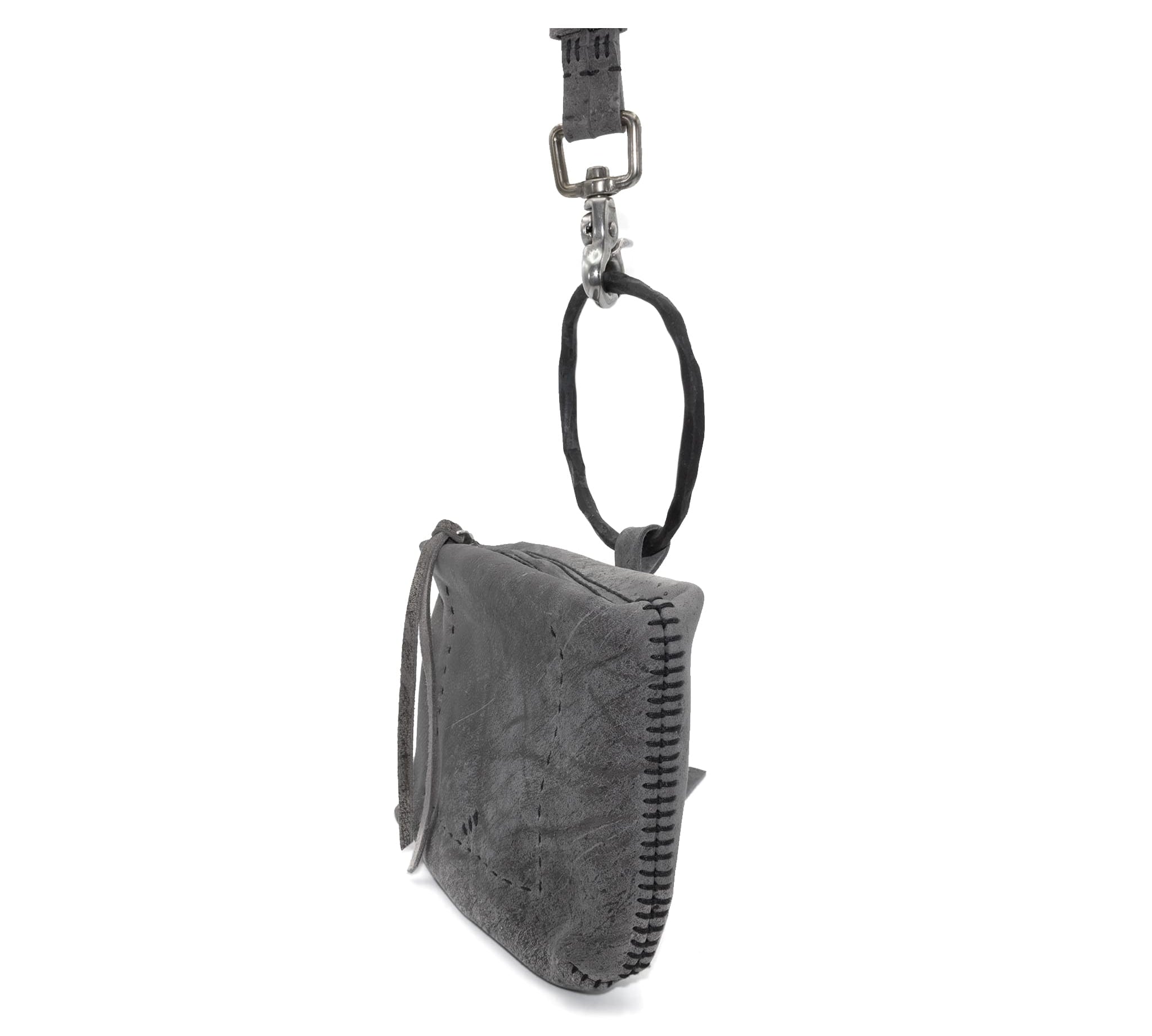 meticulously hand stitched kudu leather bag with a zipper fastening and large iron ring carry handle. an adjustable double layered shoulder strap is adorned with a distressed clip. the bag is available to buy online from uk based avant garde leather studio telierskn.com