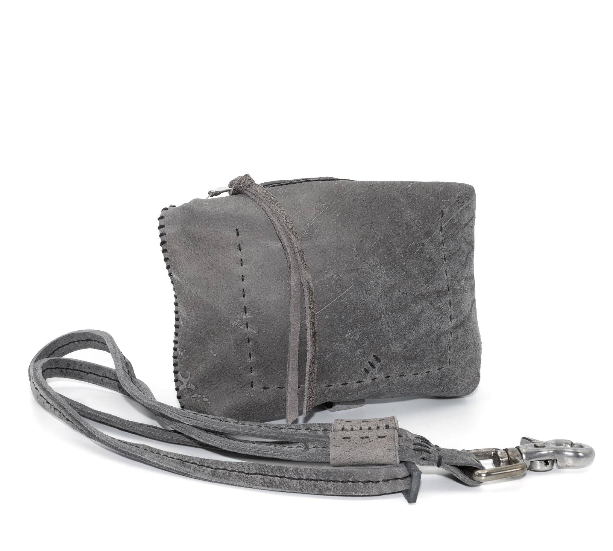 meticulously hand stitched kudu leather bag with a zipper fastening and large iron ring carry handle. an adjustable double layered shoulder strap is adorned with a distressed clip. the bag is available to buy online from uk based avant garde leather studio telierskn.com