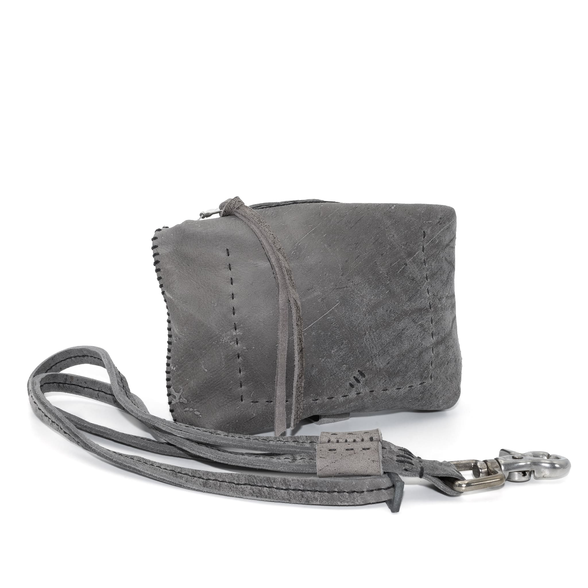 meticulously hand stitched kudu leather bag with a zipper fastening and large iron ring carry handle. an adjustable double layered shoulder strap is adorned with a distressed clip. the bag is available to buy online from uk based avant garde leather studio telierskn.com