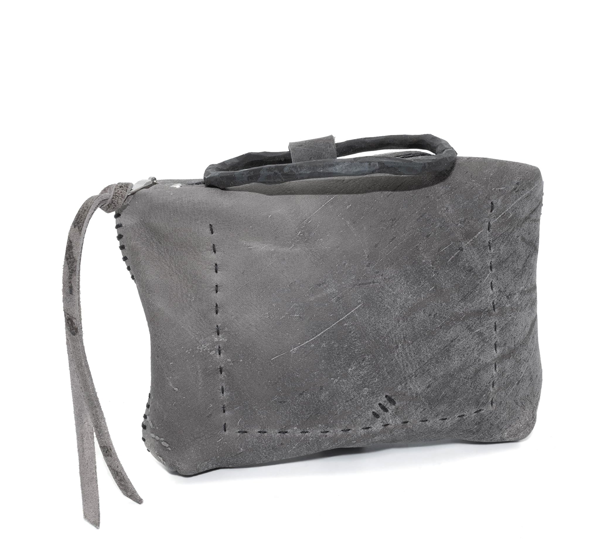 meticulously hand stitched kudu leather bag with a zipper fastening and large iron ring carry handle. an adjustable double layered shoulder strap is adorned with a distressed clip. the bag is available to buy online from uk based avant garde leather studio telierskn.com