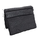 object dyed matte black reverse horse culatta leather cardholder, hand stitched over an 18 hour period without the use of machines. the leather bifold card case features multiple card slots, and a french linen lining. an open seam construction is hand stitched in a japanese linen thread. the wallet is available to buy online from avant garde leather studio atelierskn.com
