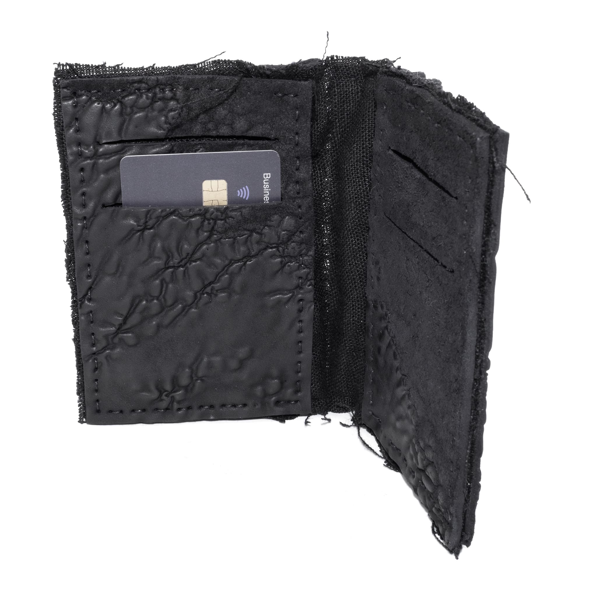 object dyed matte black reverse horse culatta leather cardholder, hand stitched over an 18 hour period without the use of machines. the leather bifold card case features multiple card slots, and a french linen lining. an open seam construction is hand stitched in a japanese linen thread. the wallet is available to buy online from avant garde leather studio atelierskn.com