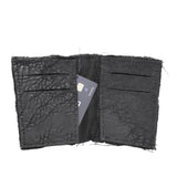 object dyed matte black reverse horse culatta leather cardholder, hand stitched over an 18 hour period without the use of machines. the leather bifold card case features multiple card slots, and a french linen lining. an open seam construction is hand stitched in a japanese linen thread. the wallet is available to buy online from avant garde leather studio atelierskn.com