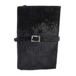 Hand stitched matte black reverse horse culatta leather journal cover with a hand forged solid .925 sterling silver buckle closure and multiple pages of 150gsm handmade cotton rag paper. available to buy online from artisanal uk based leather studio atelier skn.