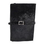 Hand stitched matte black reverse horse culatta leather journal cover with a hand forged solid .925 sterling silver buckle closure and multiple pages of 150gsm handmade cotton rag paper. available to buy online from artisanal uk based leather studio atelier skn.