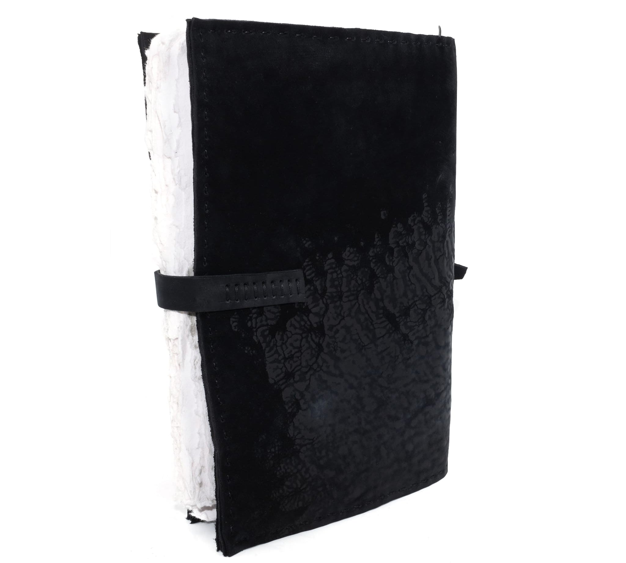 Hand stitched matte black reverse horse culatta leather journal cover with a hand forged solid .925 sterling silver buckle closure and multiple pages of 150gsm handmade cotton rag paper. available to buy online from artisanal uk based leather studio atelier skn.