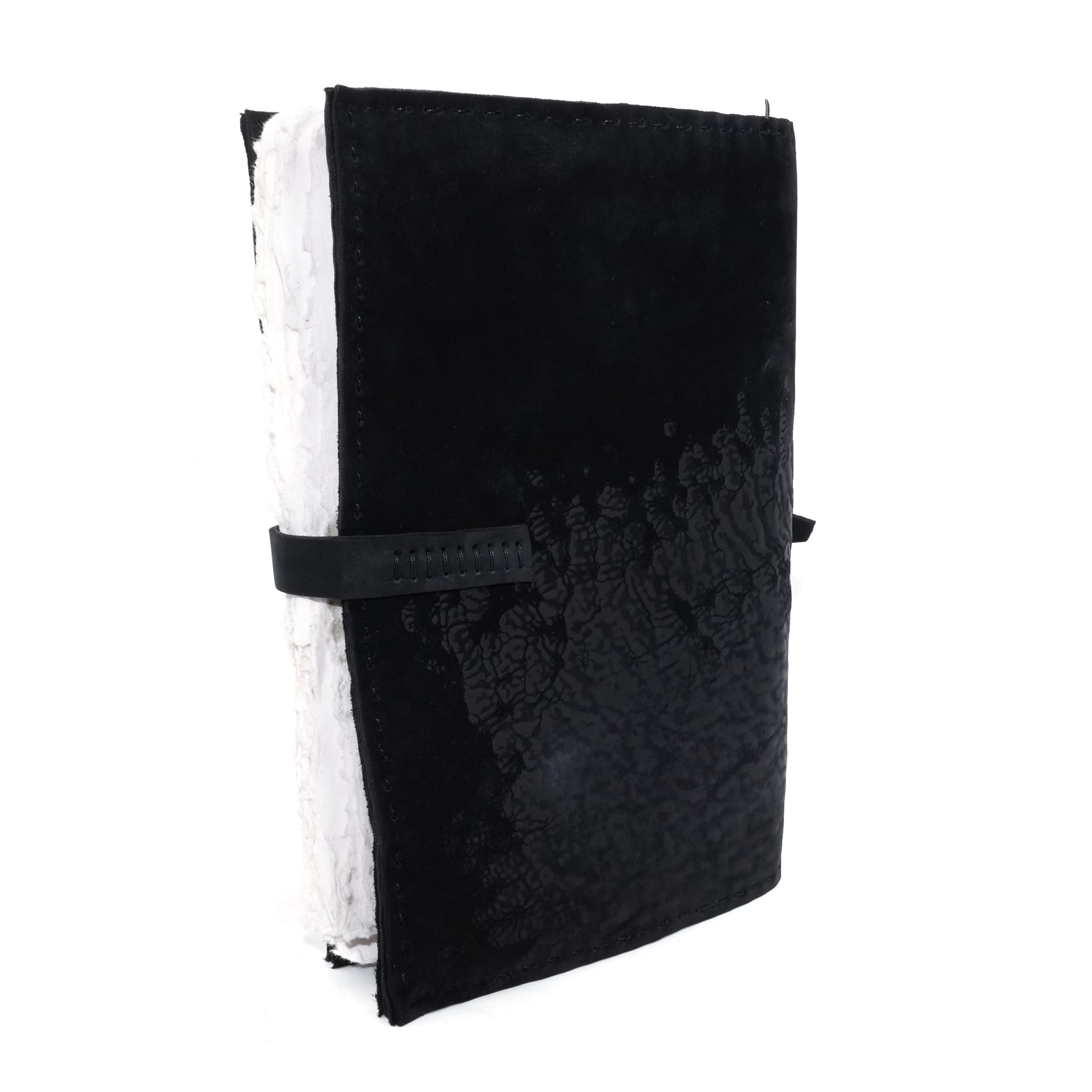 Hand stitched matte black reverse horse culatta leather journal cover with a hand forged solid .925 sterling silver buckle closure and multiple pages of 150gsm handmade cotton rag paper. available to buy online from artisanal uk based leather studio atelier skn.
