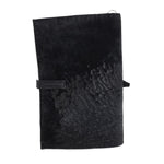 Hand stitched matte black reverse horse culatta leather journal cover with a hand forged solid .925 sterling silver buckle closure and multiple pages of 150gsm handmade cotton rag paper. available to buy online from artisanal uk based leather studio atelier skn.