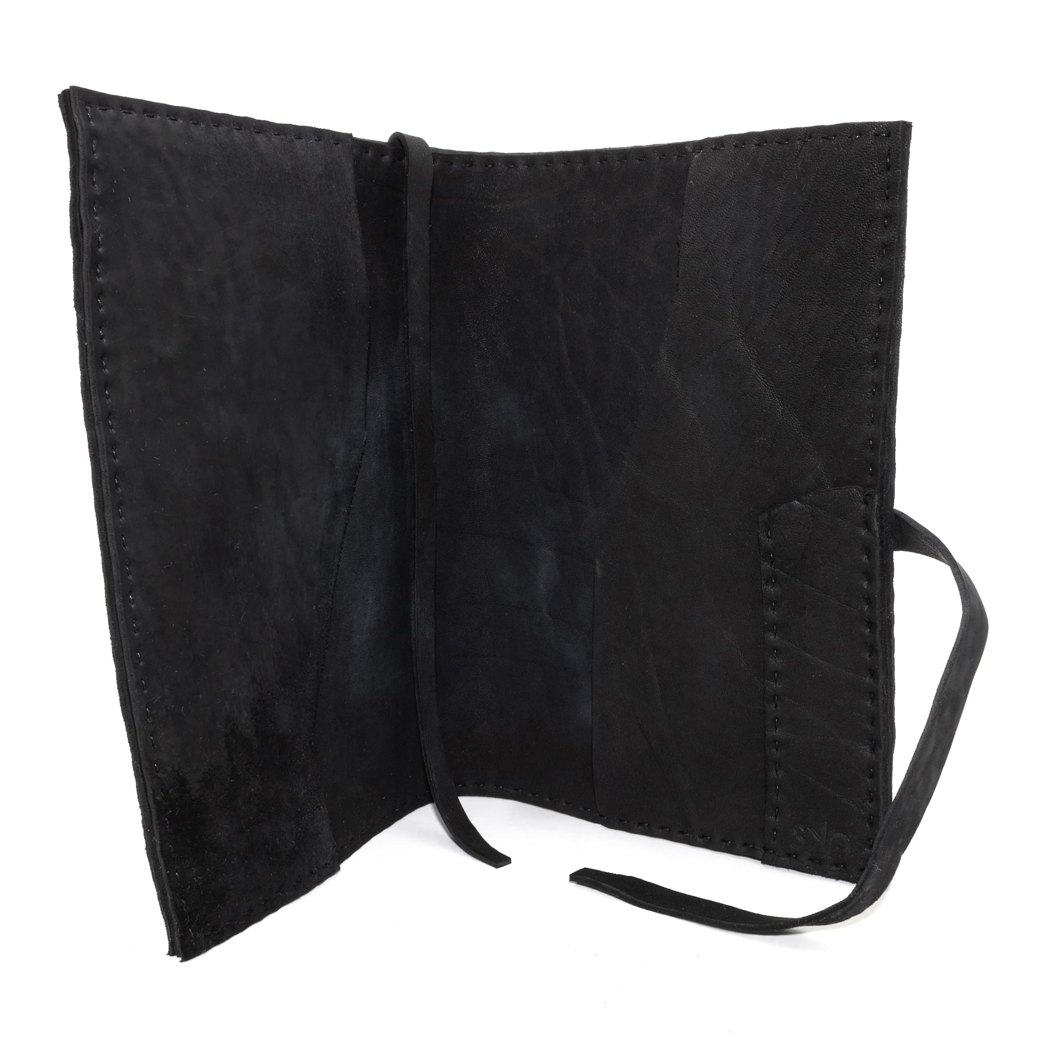 Hand stitched matte black reverse horse culatta leather journal cover with a hand forged solid .925 sterling silver buckle closure and multiple pages of 150gsm handmade cotton rag paper. available to buy online from artisanal uk based leather studio atelier skn.